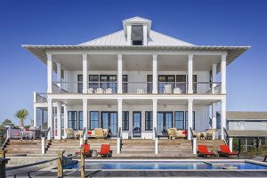 Custom home builders in Ocean County build beachy homes like this all white two-story home with beautiful pool in foreground