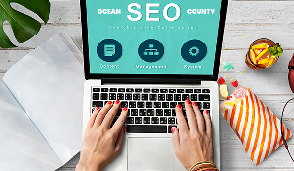 SEO OCEAN COUNTY in white font on teal screen on laptop